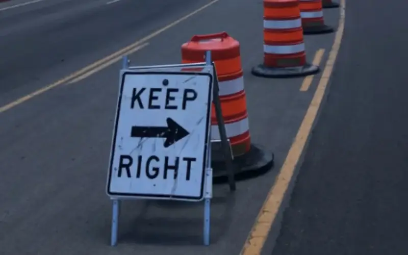 Work zone traffic control with Keep Right sign and orange construction barrels guiding vehicles through lane closure.